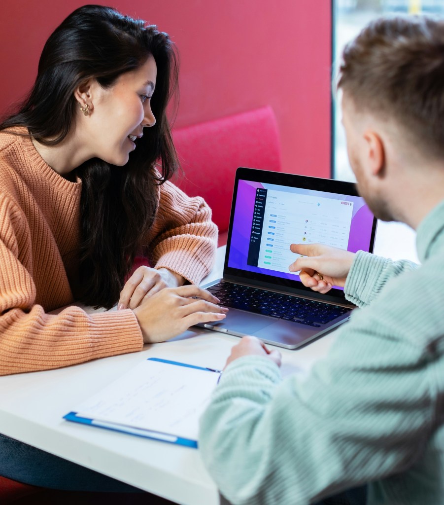 man and woman looking at laptop, smiling